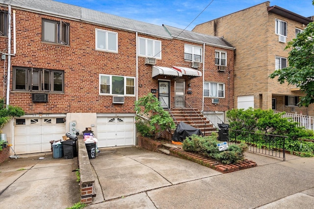 51-23 71st St, Woodside, NY 11377 - townhome / multi-family property featuring driveway, an attached garage, brick siding, and cooling unit