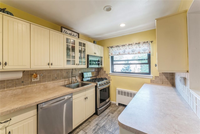 217-22 73rd Ave Upper, Upper, Oakland Gardens, NY 11364 - kitchen featuring appliances with stainless steel finishes, radiator heating unit, light countertops, tasteful backsplash, and recessed lighting