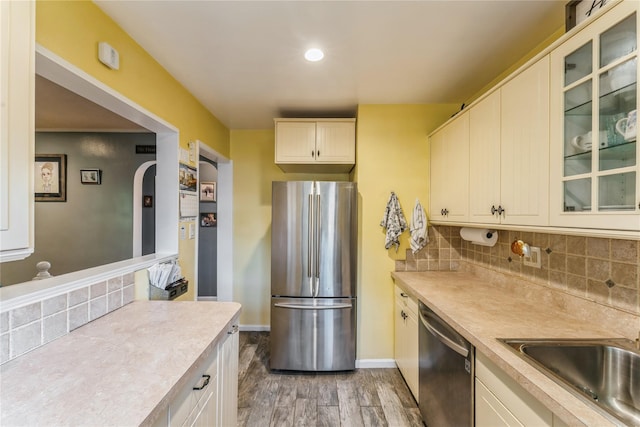 217-22 73rd Ave Upper, Upper, Oakland Gardens, NY 11364 - kitchen featuring appliances with stainless steel finishes, light wood-style flooring, light countertops, decorative backsplash, and glass insert cabinets
