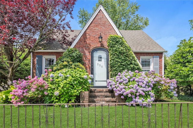 550 Nassau Blvd, West Hempstead, NY 11552 - tudor-style house with a shingled roof, brick siding, and entry steps