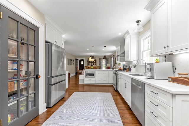 550 Nassau Blvd, West Hempstead, NY 11552 - kitchen with appliances with stainless steel finishes, a peninsula, white cabinetry, open floor plan, and dark wood-style floors