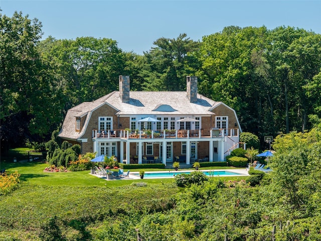 12 N Rd, Laurel Hollow, NY 11771 - rear view of property with a balcony, a gambrel roof, an outdoor pool, a lawn, and french doors