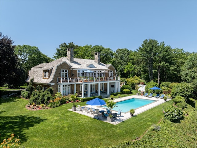 12 N Rd, Laurel Hollow, NY 11771 - rear view of house featuring a balcony, a patio, a lawn, a chimney, and an outdoor pool