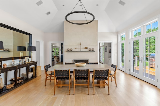 12 N Rd, Laurel Hollow, NY 11771 - dining room featuring light wood-style flooring, a tile fireplace, and high vaulted ceiling