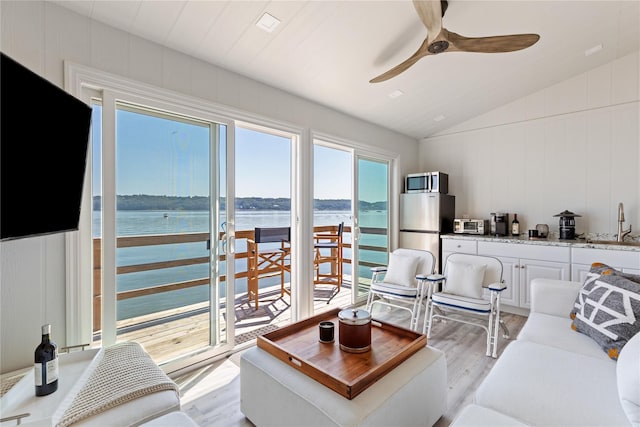 12 N Rd, Laurel Hollow, NY 11771 - living room featuring light wood finished floors, ceiling fan, lofted ceiling, a water view, and a decorative wall