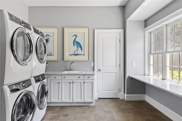12 N Rd, Laurel Hollow, NY 11771 - laundry room featuring stacked washing machine and dryer, cabinet space, healthy amount of natural light, and stone finish flooring