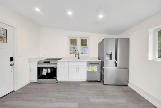 10 Pioneer Trl, Monroe, NY 10950 - kitchen featuring stainless steel appliances, light wood-style floors, light countertops, white cabinetry, and lofted ceiling