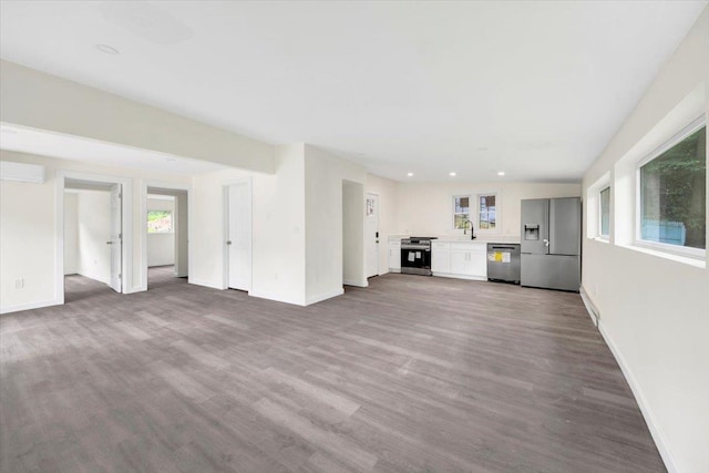10 Pioneer Trl, Monroe, NY 10950 - unfurnished living room with wood finished floors, a wall mounted AC, and recessed lighting