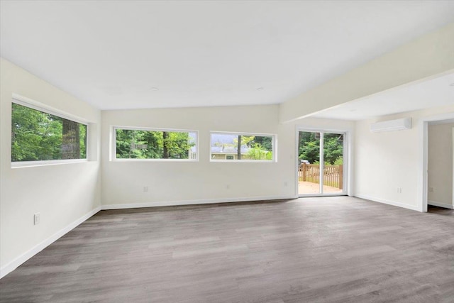 10 Pioneer Trl, Monroe, NY 10950 - spare room with a wall mounted air conditioner, plenty of natural light, wood finished floors, and vaulted ceiling