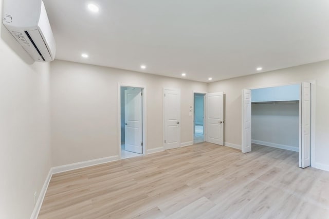 2 Foxwood Rd, Kings Point, NY 11024 - unfurnished bedroom featuring a wall mounted air conditioner, recessed lighting, light wood-type flooring, and ensuite bathroom