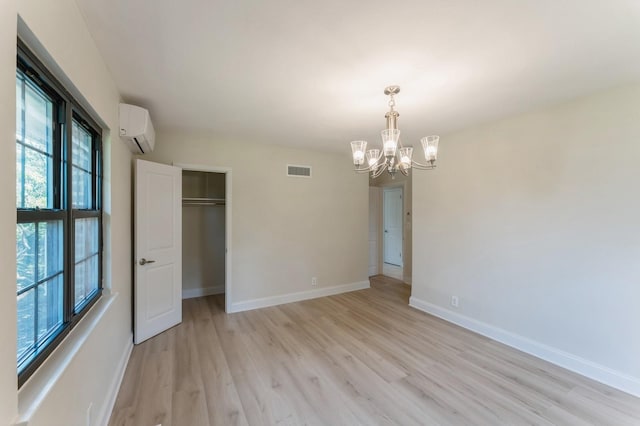 2 Foxwood Rd, Kings Point, NY 11024 - unfurnished bedroom with a wall mounted AC, a chandelier, light wood-style flooring, and a closet