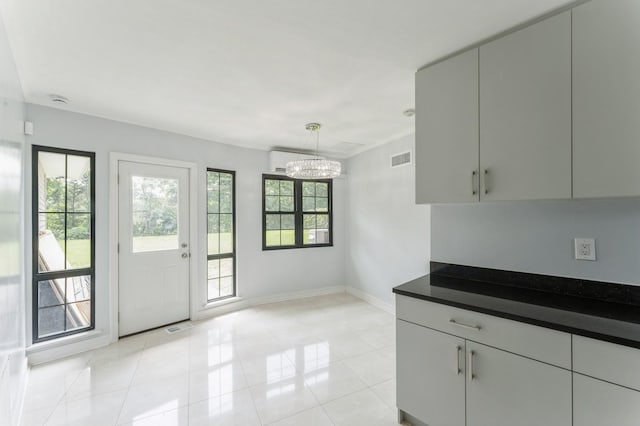 2 Foxwood Rd, Kings Point, NY 11024 - kitchen featuring dark countertops, a chandelier, light tile patterned floors, and pendant lighting
