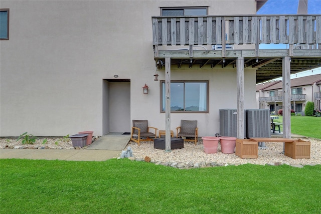 1 Anchorage Way Unit 301, Freeport, NY 11520 - rear view of house with stucco siding, a lawn, and a deck