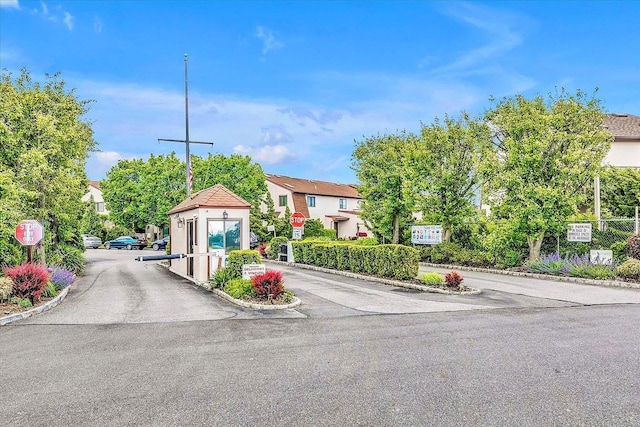 1 Anchorage Way Unit 301, Freeport, NY 11520 - view of asphalt road featuring traffic signs, curbs, a gated entry, and a residential view