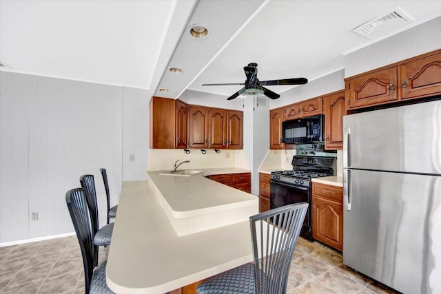 107 Croydon Rd, Yonkers, NY 10710 - kitchen with black appliances, brown cabinetry, and a ceiling fan