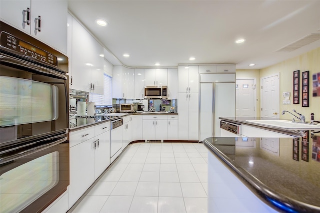 7015 170th St, Fresh Meadows, NY 11365 - kitchen featuring stainless steel microwave, paneled fridge, dark countertops, white cabinetry, and white dishwasher