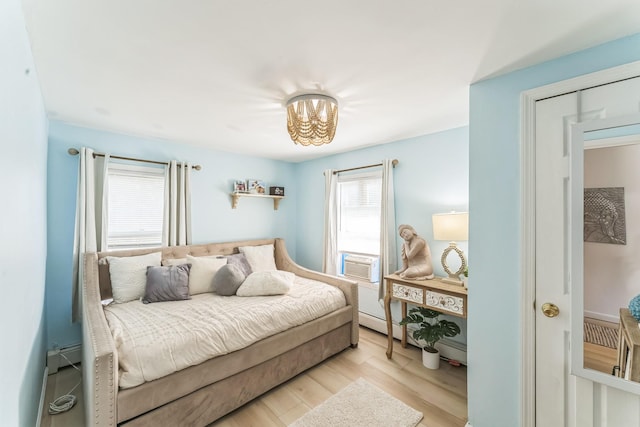 90 Redmond Ave, Bay Shore, NY 11706 - bedroom featuring cooling unit, wood finished floors, a chandelier, and a baseboard heating unit