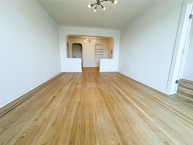 35-24 78th St Unit A67, Jackson Heights, NY 11372 - empty room featuring a chandelier, wood finished floors, crown molding, and arched walkways