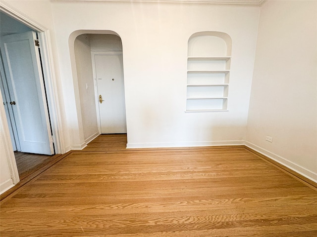 35-24 78th St Unit A67, Jackson Heights, NY 11372 - spare room with built in shelves, arched walkways, and light wood-style flooring