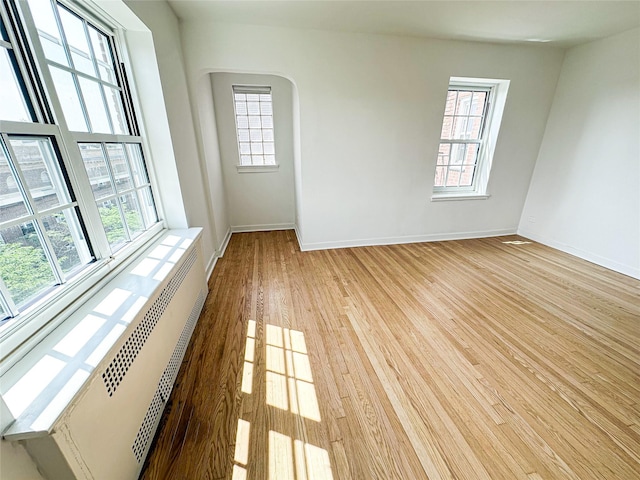 35-24 78th St Unit A67, Jackson Heights, NY 11372 - spare room with light wood-type flooring, arched walkways, and radiator heating unit
