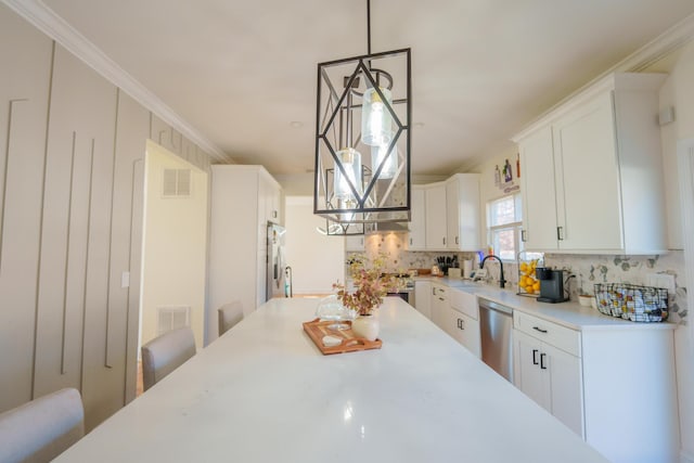 37 William St, Bohemia, NY 11716 - kitchen featuring backsplash, stainless steel appliances, light countertops, white cabinetry, and crown molding