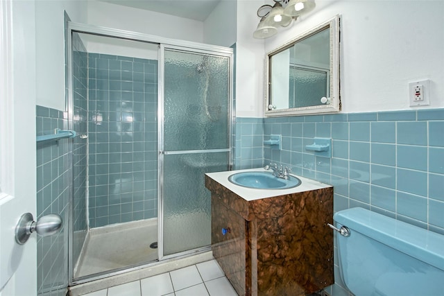 115 Dehaven Dr Unit 214, Yonkers, NY 10703 - bathroom featuring vanity, tile walls, a stall shower, tile patterned flooring, and a wainscoted wall