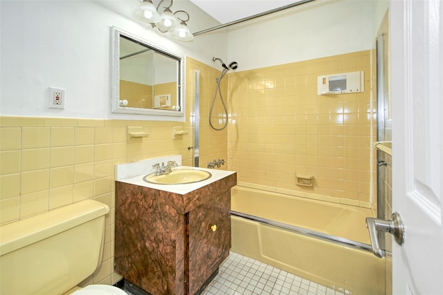 115 Dehaven Dr Unit 214, Yonkers, NY 10703 - bathroom featuring vanity, washtub / shower combination, tile walls, tile patterned floors, and wainscoting