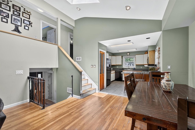 3324 Sycamore Ln, Yorktown Heights, NY 10598 - dining space featuring light wood-style floors, vaulted ceiling, a skylight, stairway, and recessed lighting