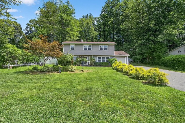 3324 Sycamore Ln, Yorktown Heights, NY 10598 - view of front of house with an attached garage, a front yard, and asphalt driveway