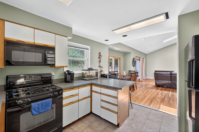 3324 Sycamore Ln, Yorktown Heights, NY 10598 - kitchen featuring black appliances, a peninsula, white cabinets, lofted ceiling, and open floor plan