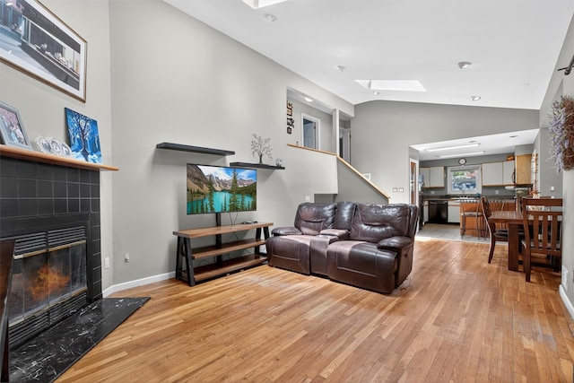 3324 Sycamore Ln, Yorktown Heights, NY 10598 - living area featuring a skylight, light wood-style flooring, a tile fireplace, and high vaulted ceiling