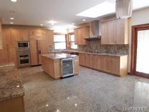 52 Snapdragon Ln, Roslyn Heights, NY 11577 - kitchen with wall chimney range hood, beverage cooler, decorative backsplash, a kitchen island, and recessed lighting