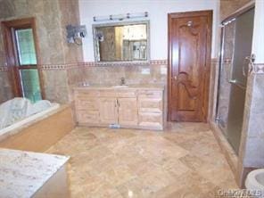 52 Snapdragon Ln, Roslyn Heights, NY 11577 - bathroom featuring vanity, a shower stall, tile walls, and a bathtub