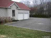 52 Snapdragon Ln, Roslyn Heights, NY 11577 - view of property exterior featuring asphalt driveway, an attached garage, and a lawn