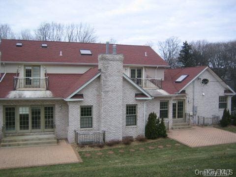 52 Snapdragon Ln, Roslyn Heights, NY 11577 - rear view of property with a balcony, a patio area, a chimney, and a lawn