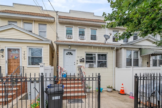 74-25 93rd Ave, Woodhaven, NY 11421 - traditional home featuring a fenced front yard, cooling unit, a gate, and entry steps