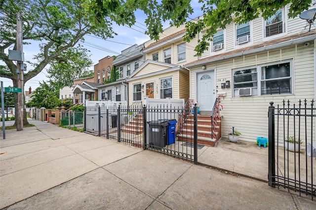 74-25 93rd Ave, Woodhaven, NY 11421 - traditional home featuring a fenced front yard, entry steps, a residential view, and cooling unit