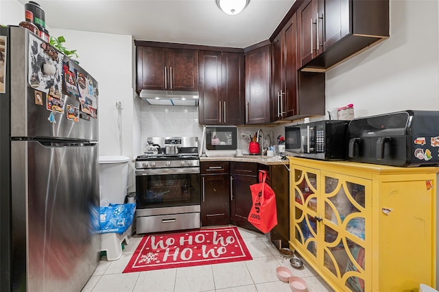 74-25 93rd Ave, Woodhaven, NY 11421 - kitchen with stainless steel appliances, under cabinet range hood, light countertops, dark brown cabinetry, and tasteful backsplash