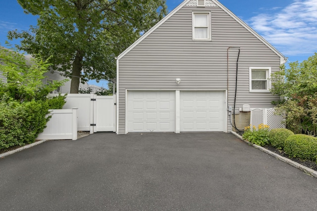 3309 Balsam St, Oceanside, NY 11572 - view of side of home with a gate, asphalt driveway, and an attached garage