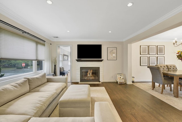 3309 Balsam St, Oceanside, NY 11572 - living area with dark wood-type flooring, crown molding, a fireplace with flush hearth, recessed lighting, and a chandelier