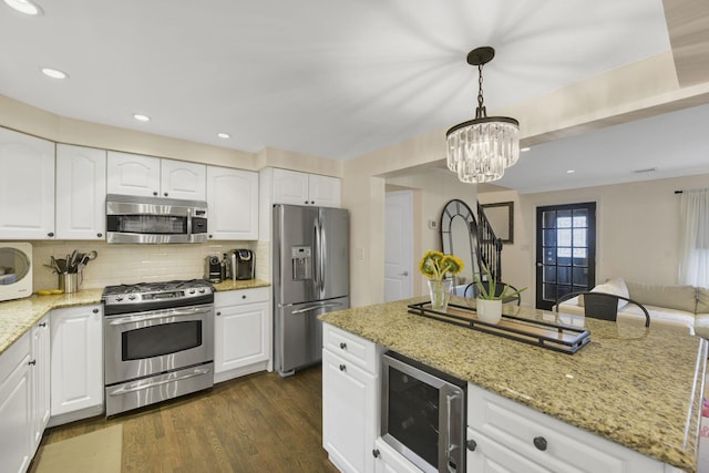 3309 Balsam St, Oceanside, NY 11572 - kitchen with appliances with stainless steel finishes, light stone counters, decorative backsplash, pendant lighting, and dark wood-style flooring