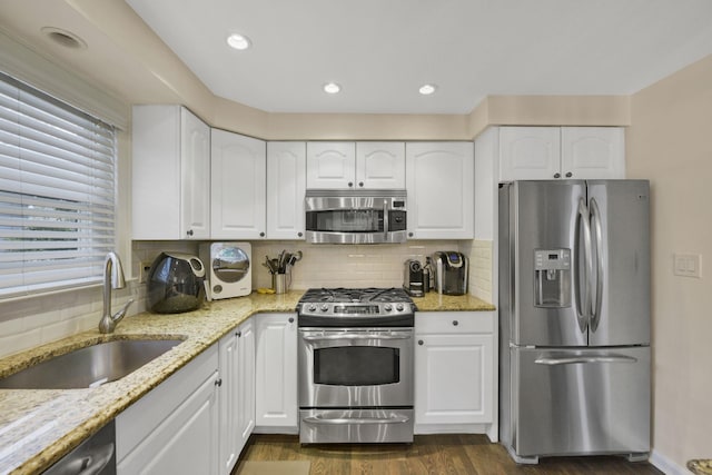 3309 Balsam St, Oceanside, NY 11572 - kitchen featuring stainless steel appliances, dark wood-style floors, light stone countertops, white cabinets, and recessed lighting