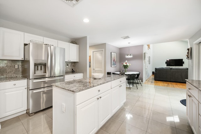 70 Hickory St, Blauvelt, NY 10913 - kitchen featuring stainless steel refrigerator with ice dispenser, backsplash, a center island, light stone countertops, and light tile patterned flooring