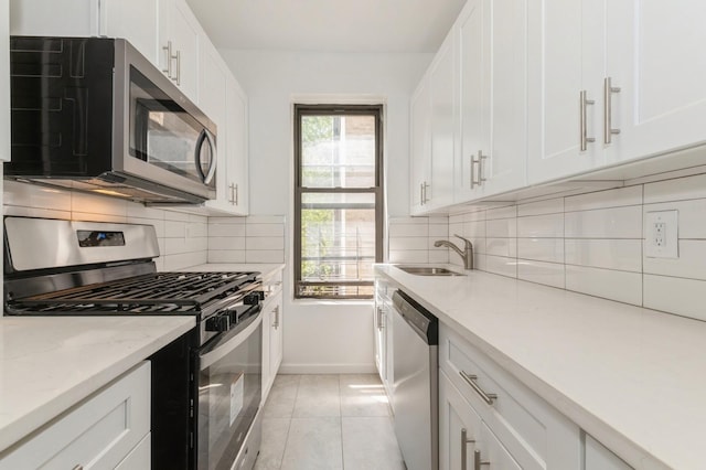 1110 Caton Ave Unit 5C, Brooklyn, NY 11218 - kitchen with appliances with stainless steel finishes, white cabinets, decorative backsplash, light stone countertops, and light tile patterned flooring