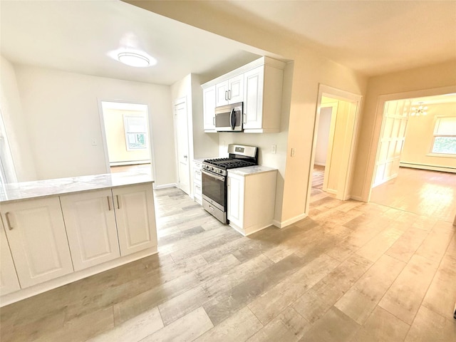 55 Red Mill Rd, Cortlandt Manor, NY 10567 - kitchen with stainless steel appliances, light wood-type flooring, white cabinetry, a chandelier, and baseboard heating