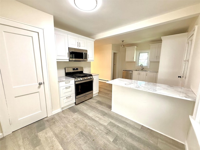 55 Red Mill Rd, Cortlandt Manor, NY 10567 - kitchen with appliances with stainless steel finishes, white cabinetry, light wood-style flooring, and light stone counters