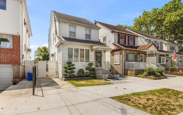 96-36 149th Ave, Ozone Park, NY 11417 - townhome / multi-family property with a gate, concrete driveway, stone siding, and roof with shingles