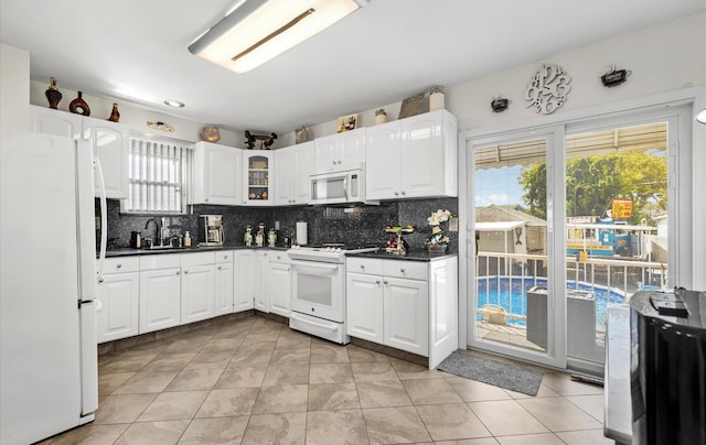 96-36 149th Ave, Ozone Park, NY 11417 - kitchen with white appliances, dark countertops, tasteful backsplash, and white cabinets