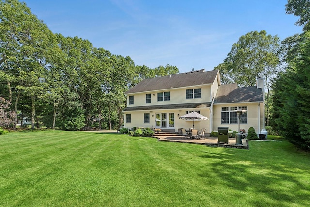 1 Alexis, Speonk, NY 11972 - rear view of house featuring a patio area, a lawn, a chimney, and french doors