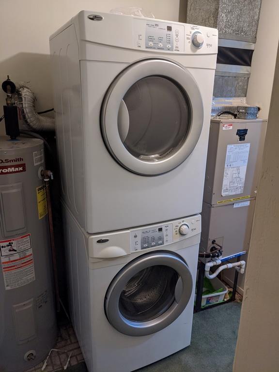 972 Skyline Dr Unit 972, Coram, NY 11727 - laundry room featuring water heater and stacked washing machine and dryer